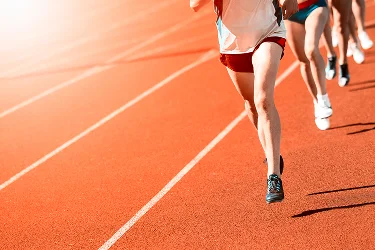 Runners sprinting on an athletics track during an outdoor race event with dynamic sports motion